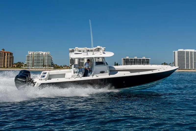 Slide: The Image of 2017 Contender 39 ST boat cruising on blue water near coastal buildings. - 49