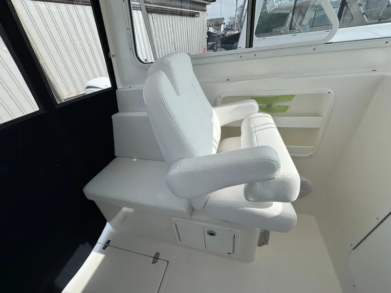 Slide: The Image of 2025 NorthCoast 255 HT boat interior with white seating and window view. - 17