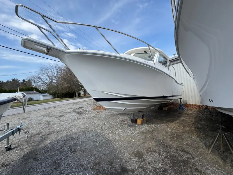 Slide: The Image of 2025 NorthCoast 255 HT boat on dry dock, side view under clear sky. - 2
