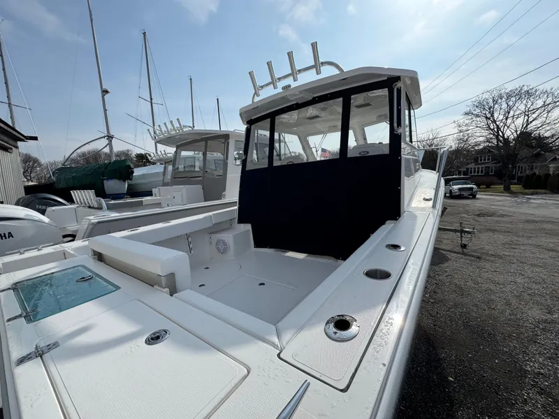 Slide: The Image of 2025 NorthCoast 255 HT boat with spacious deck and modern design in a marina setting. - 4