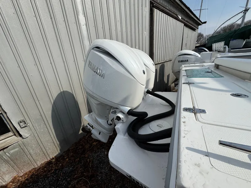 Slide: The Image of 2025 NorthCoast 255 HT boat with Yamaha outboard motor, docked near a metal building. - 5