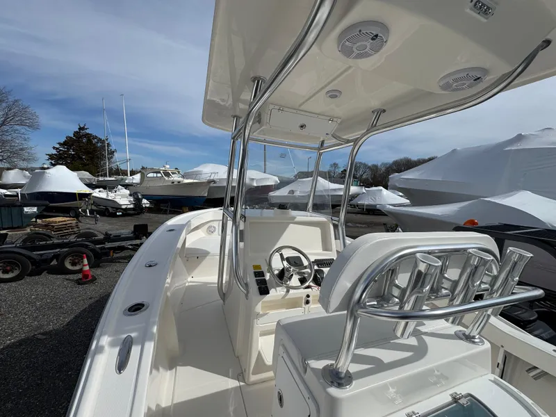 Slide: The Image of 2025 NorthCoast 230 Center Console boat with sleek design, parked in a marina. - 11