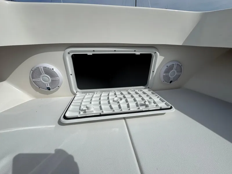 Slide: The Image of 2025 NorthCoast 230 Center Console boat with open storage hatch and speakers. - 13