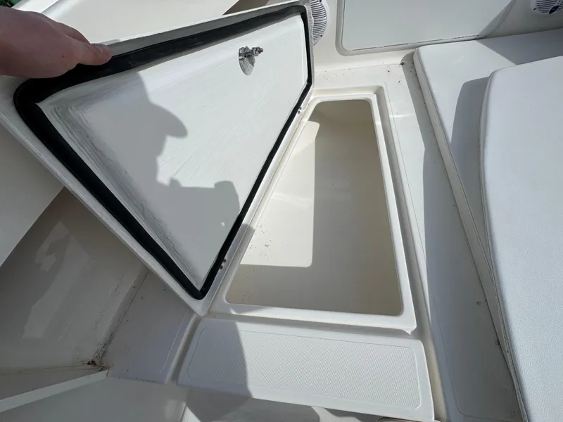 Slide: The Image of 2025 NorthCoast 230 Center Console boat storage compartment open, showcasing interior space. - 14