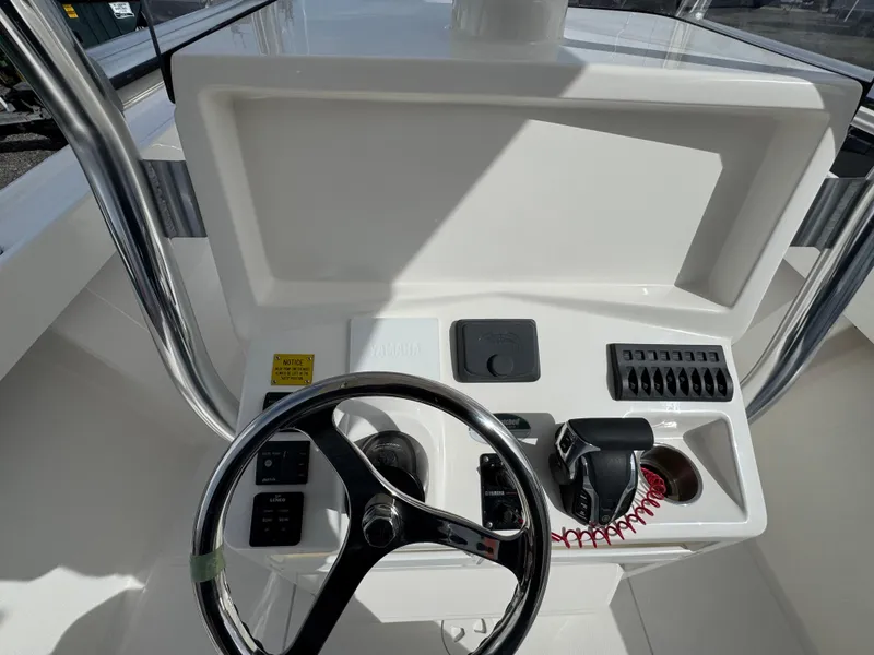 Slide: The Image of 2025 NorthCoast 230 Center Console boat dashboard with steering wheel and controls. - 8