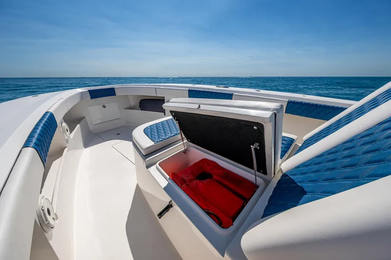 Slide: The Image of Front Runner 39 boat interior with open storage compartment, blue seating, ocean view, 2020 model. - 11