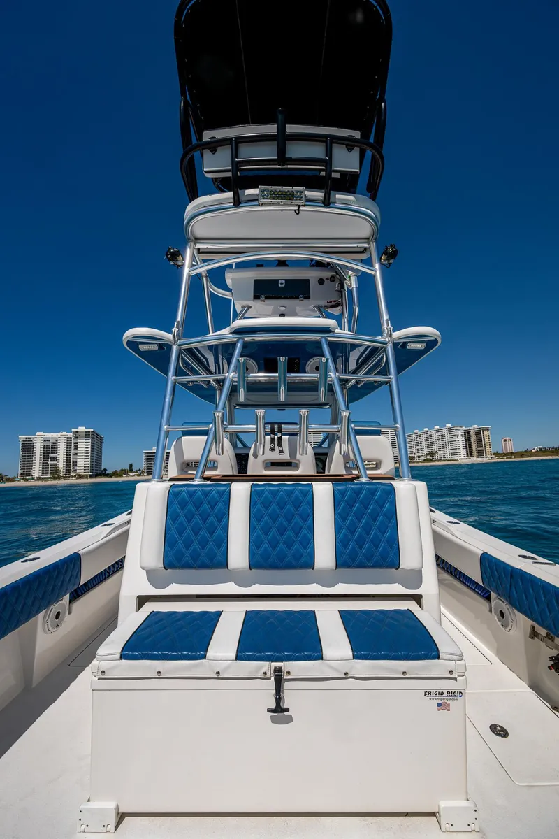 Slide: The Image of 2020 Front Runner 39 boat with blue seating, ocean view, and city skyline in the background. - 17