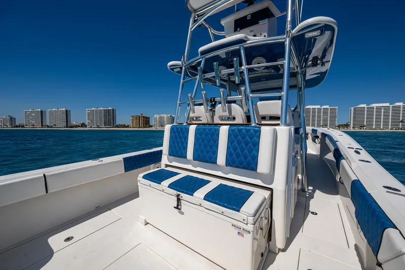 Slide: The Image of 2020 Front Runner 39 boat with blue seating, ocean view, and city skyline in the background. - 18