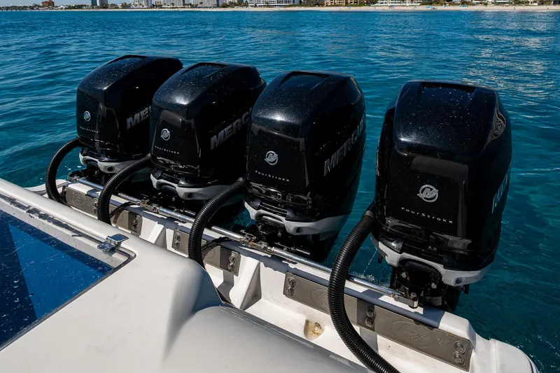 Slide: The Image of Four powerful outboard motors on a 2020 Front Runner 39 boat in clear blue water. - 20
