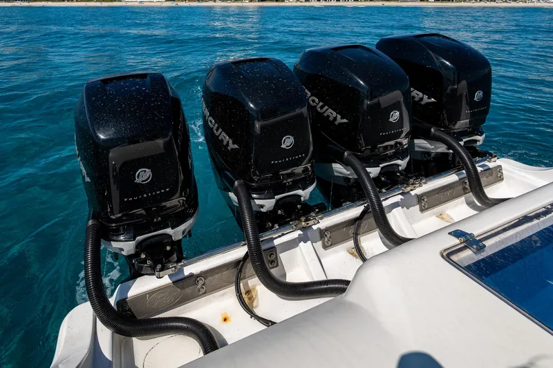 Slide: The Image of Four Mercury outboard engines on a 2020 Front Runner 39 boat in clear blue water. - 22