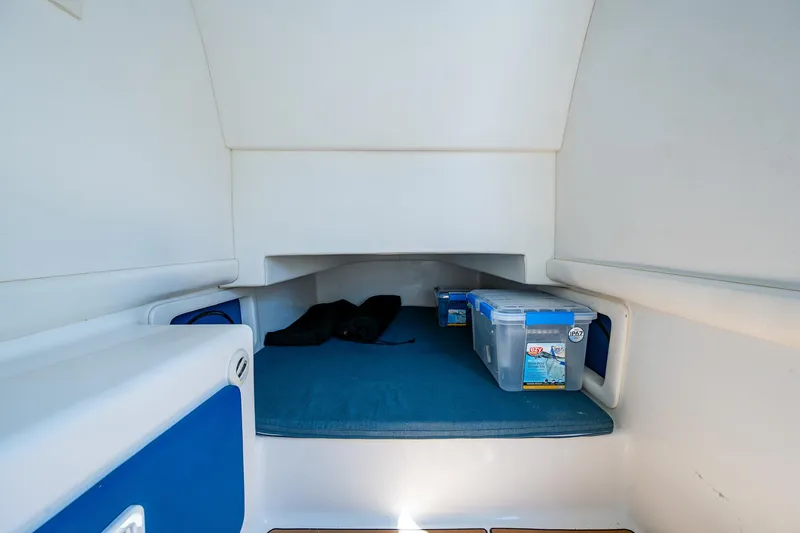 Slide: The Image of Interior cabin of 2020 Front Runner 39 boat with storage containers and blue bedding. - 25