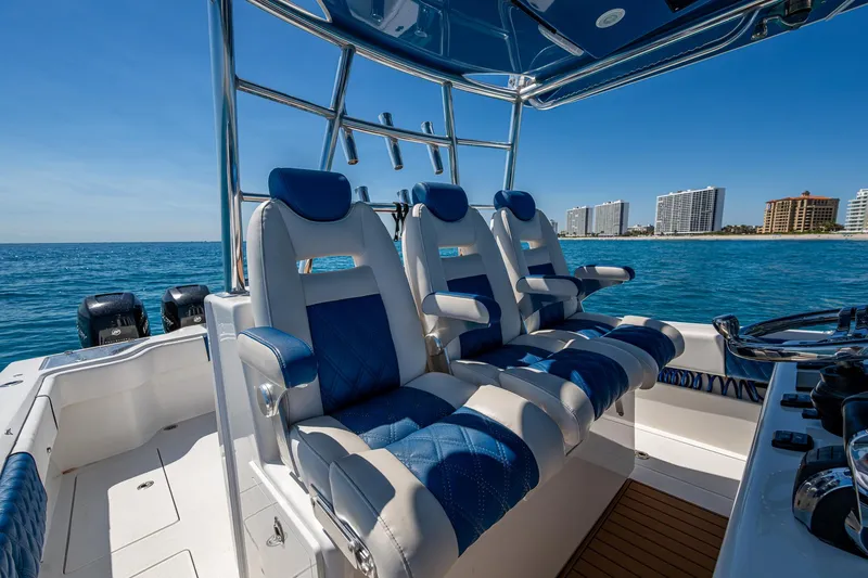 Slide: The Image of 2020 Front Runner 39 boat interior with blue and white seating, ocean view, and city skyline. - 30