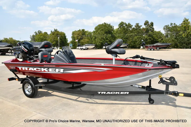 Slide: The Image of 2025 Tracker Pro Team 175 Crappie Edition boat, red and silver, parked on a trailer. - 75