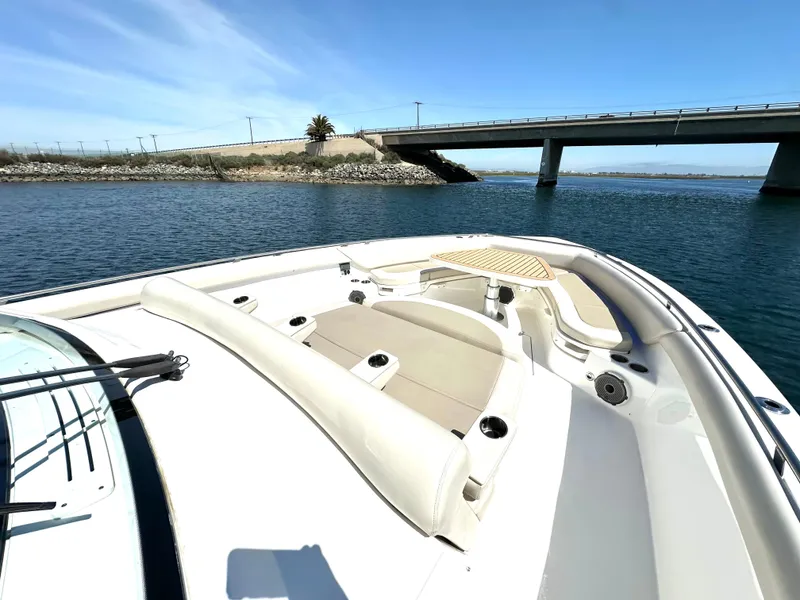 Slide: The Image of 2020 Boston Whaler 420 Outrage boat on water near a bridge, showcasing spacious deck. - 15