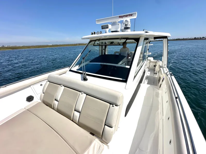 Slide: The Image of 2020 Boston Whaler 420 Outrage boat on calm water, featuring spacious deck and modern design. - 24