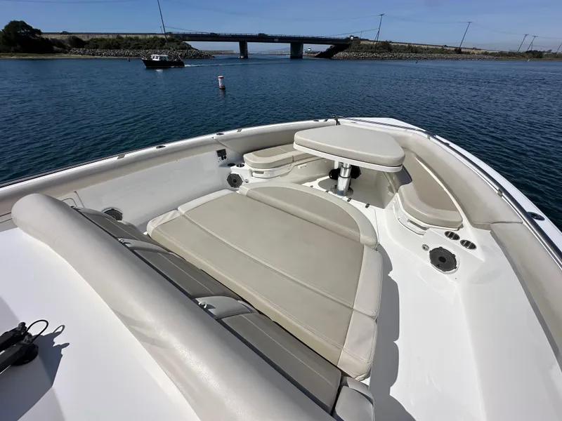 Slide: The Image of 2020 Boston Whaler 420 Outrage boat with spacious seating, on calm water near a bridge. - 27