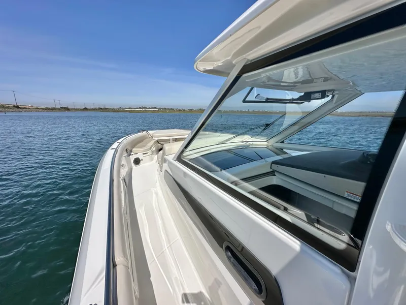 Slide: The Image of 2020 Boston Whaler 420 Outrage boat on calm water, showcasing sleek design and spacious deck. - 28