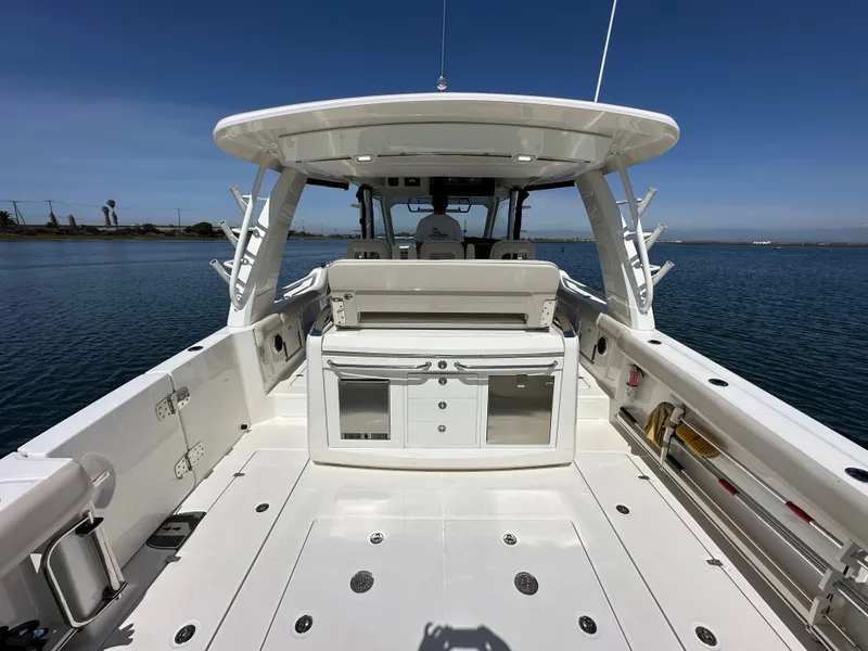 Slide: The Image of 2020 Boston Whaler 420 Outrage boat deck with seating and storage, on calm water. - 35