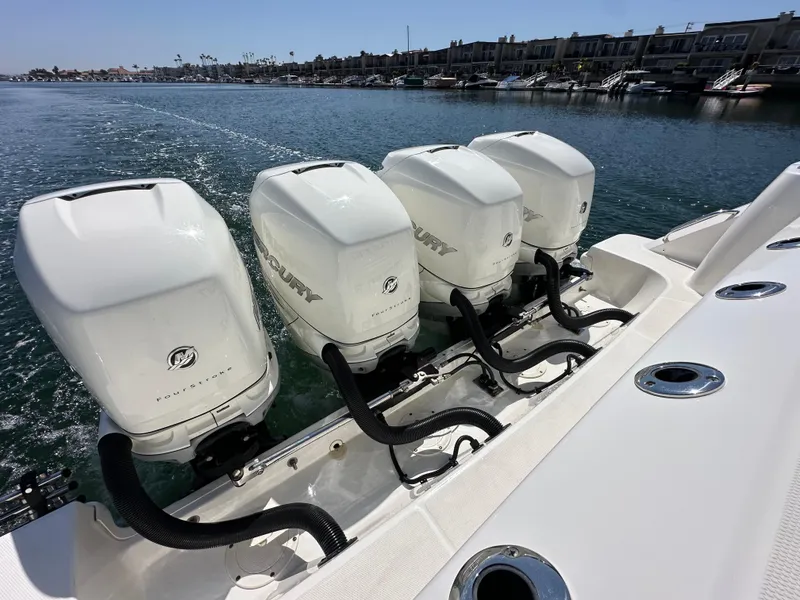Slide: The Image of Four powerful outboard engines on a 2020 Boston Whaler 420 Outrage, cruising on calm waters. - 40