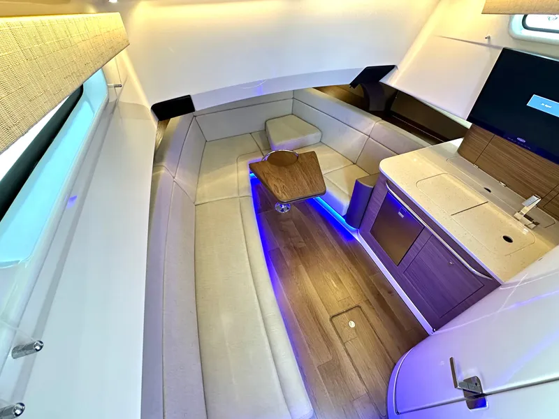 Slide: The Image of Luxurious interior of 2020 Boston Whaler 420 Outrage with seating, table, and ambient lighting. - 42