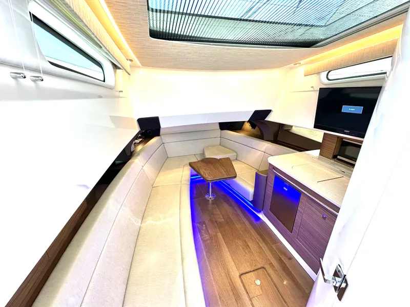 Slide: The Image of 2020 Boston Whaler 420 Outrage interior with modern seating, wood accents, and ambient lighting. - 44