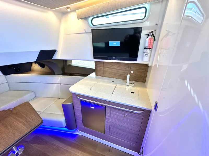 Slide: The Image of Interior of 2020 Boston Whaler 420 Outrage, featuring a modern kitchenette and seating area. - 46