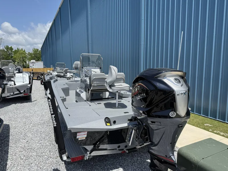 Slide: The Image of 2025 Xpress Hyper-Lift Series H22B boat with Yamaha engine, parked outdoors. - 2