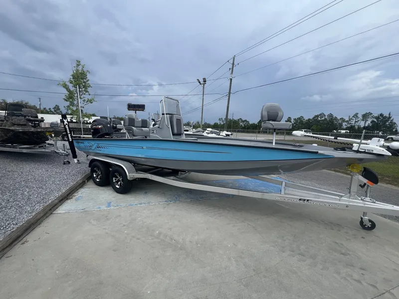 Slide: The Image of 2025 Xpress Hyper-Lift Series H22B boat on trailer, parked outdoors under cloudy sky. - 1