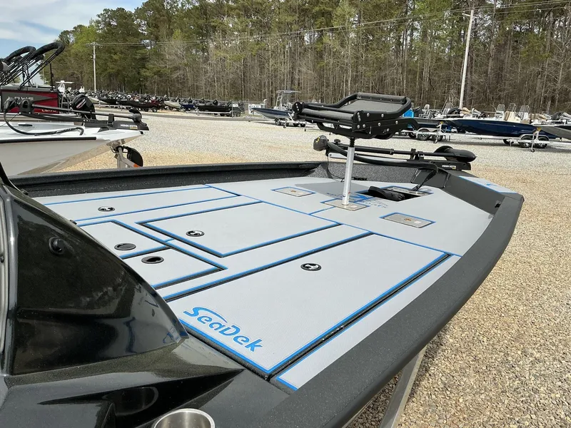Slide: The Image of 2025 Xpress Hyper-Lift Crappie Series H20 boat with SeaDek flooring, parked outdoors. - 2