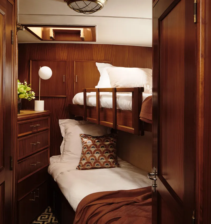 Slide: The Image of 1981 Hatteras Motor Yacht cabin with wooden interior, bunk beds, and cozy decor. - 19
