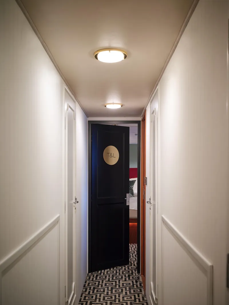 Slide: The Image of Hallway inside 1981 Hatteras Motor Yacht with open door and patterned carpet. - 21