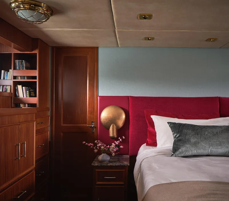 Slide: The Image of Luxurious 1981 Hatteras Motor Yacht bedroom with elegant wood furnishings and plush bedding. - 23