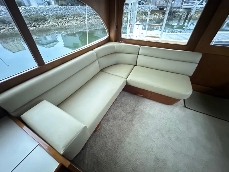 Slide: The Image of 1988 Buddy Davis Convertible yacht interior with beige leather seating and large windows. - 13