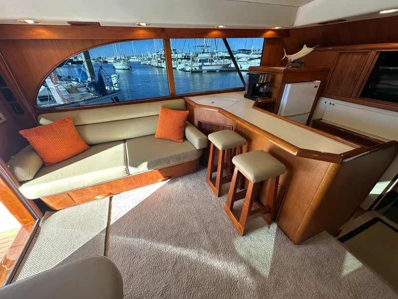 Slide: The Image of Luxurious 1988 Buddy Davis Convertible yacht interior with seating, bar stools, and marina view. - 16