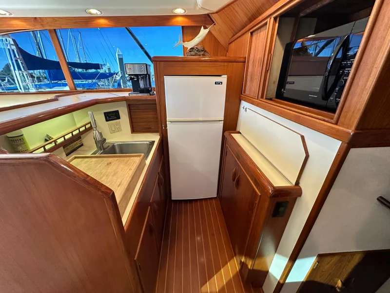 Slide: The Image of 1988 Buddy Davis Convertible yacht kitchen with wood finish, sink, and refrigerator. - 18