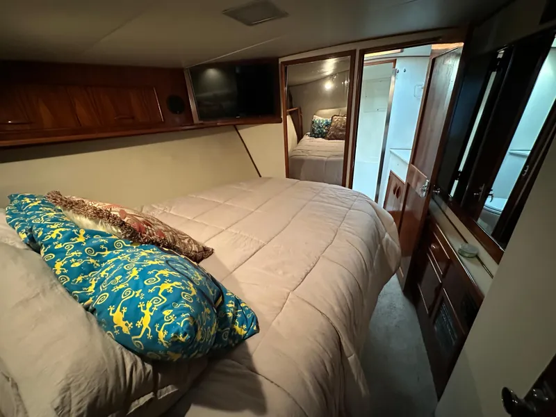 Slide: The Image of Cozy bedroom in 1988 Buddy Davis Convertible yacht with plush bedding and wooden accents. - 29