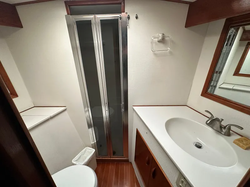 Slide: The Image of 1988 Buddy Davis Convertible yacht bathroom with shower, sink, and wooden accents. - 32