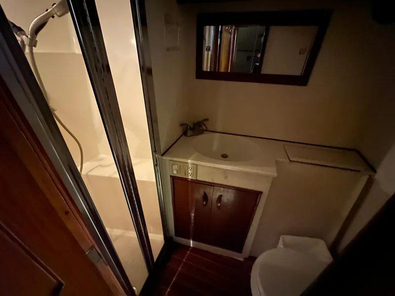 Slide: The Image of 1988 Buddy Davis Convertible yacht bathroom with shower, sink, and mirror. - 34