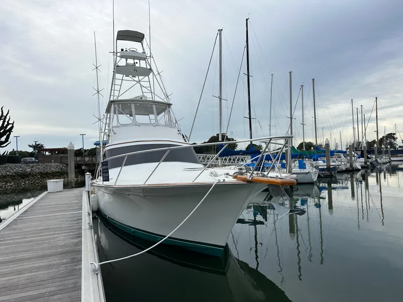 Slide: The Image of 1988 Buddy Davis Convertible yacht docked at a marina, surrounded by sailboats. - 4