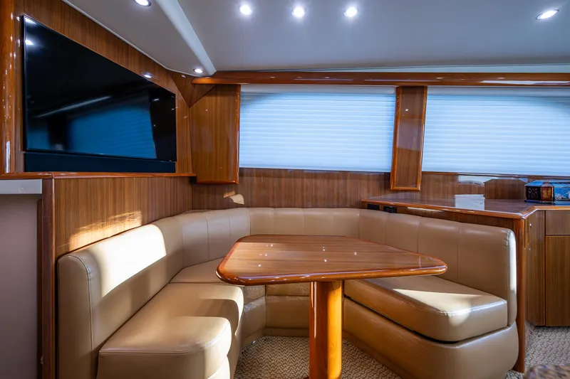 Slide: The Image of Luxurious interior of 2005 Viking 52 Convertible yacht with leather seating and wooden table. - 21