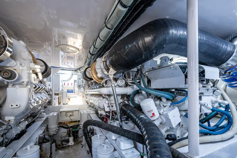 Slide: The Image of Engine room of a 2005 Viking 52 Convertible yacht, showcasing complex machinery and piping. - 23