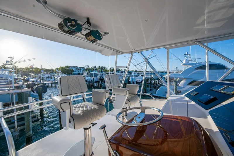 Slide: The Image of Interior view of 2005 Viking 52 Convertible yacht's helm with marina backdrop. - 28