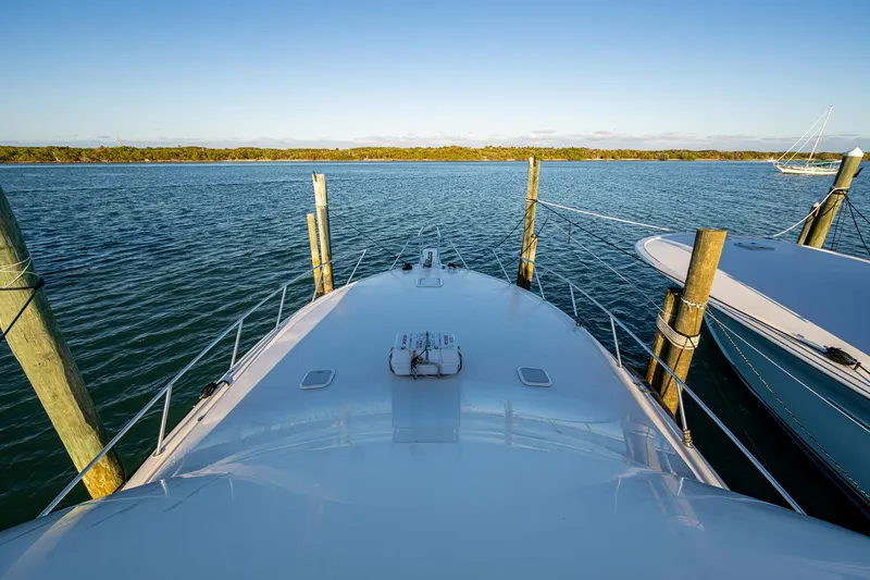 Slide: The Image of 2005 Viking 52 Convertible yacht docked on calm water under clear blue sky. - 31