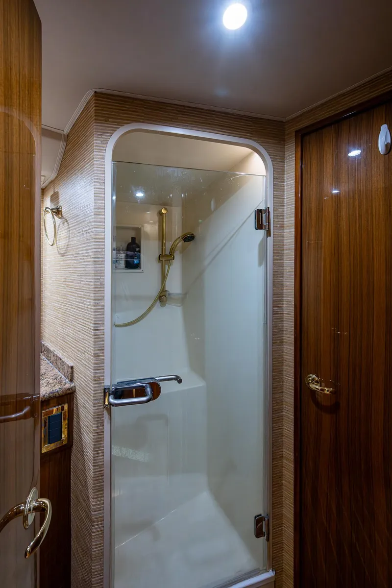 Slide: The Image of 2005 Viking 52 Convertible yacht bathroom with glass shower and wooden accents. - 36