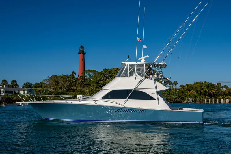Slide: The Image of 2005 Viking 52 Convertible yacht cruising near a lighthouse on a sunny day. - 4