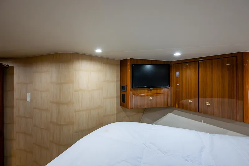 Slide: The Image of Luxurious cabin interior of 2005 Viking 52 Convertible yacht with TV and wood paneling. - 43