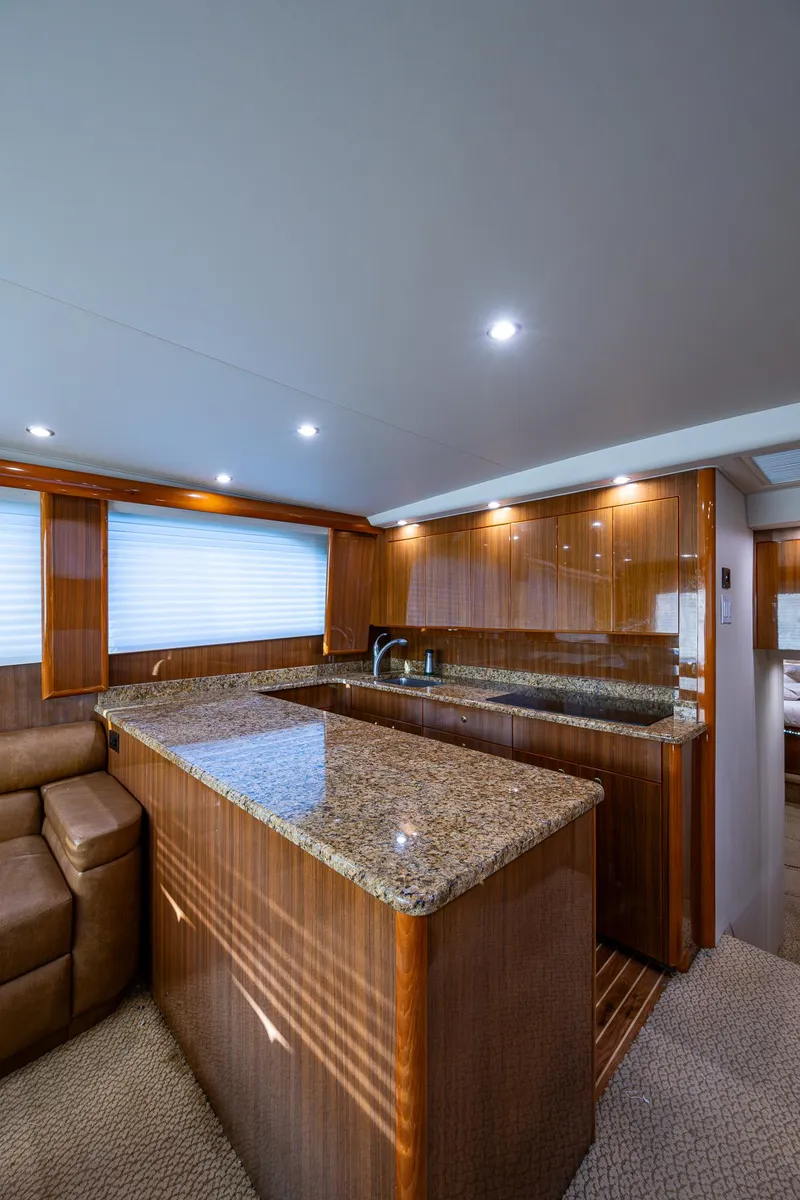 Slide: The Image of Luxurious interior of 2005 Viking 52 Convertible yacht with granite countertops and wood paneling. - 46