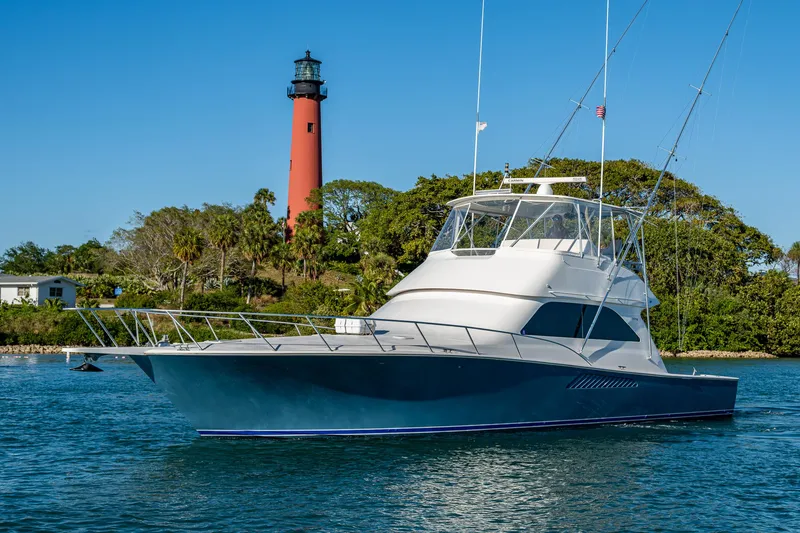 Slide: The Image of 2005 Viking 52 Convertible yacht near a lighthouse on a sunny day. - 5