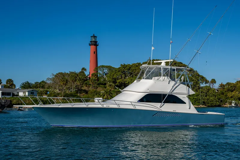 Slide: The Image of 2005 Viking 52 Convertible yacht near a lighthouse on a sunny day. - 6