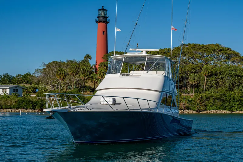 Slide: The Image of 2005 Viking 52 Convertible yacht near a lighthouse on a sunny day. - 7